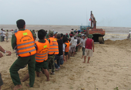 Bộ đội giúp dân trục vớt tàu cá bị sóng biển đánh úp