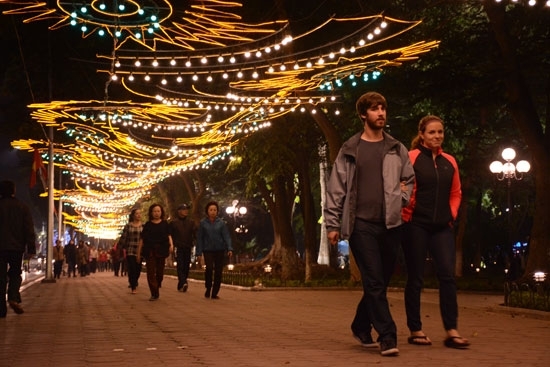 Du khách và nhân dân Thủ đô đi dạo dưới hàng đèn được trang trí đẹp mắt bên Hồ Hoàn Kiếm.