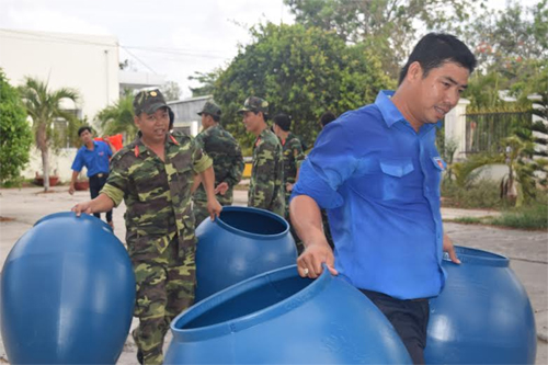 Cùng với các chiến sĩ, các đoàn viên thanh niên địa phương cũng tham gia vận chuyển thùng chứa nước đến các hộ dân.