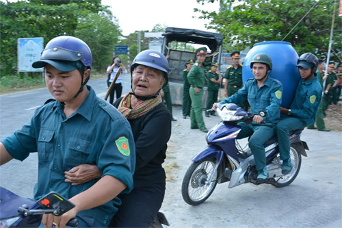 Lực lượng dân quân xã cùng tham gia vận chuyển thùng chứa nước cho các hộ dân.