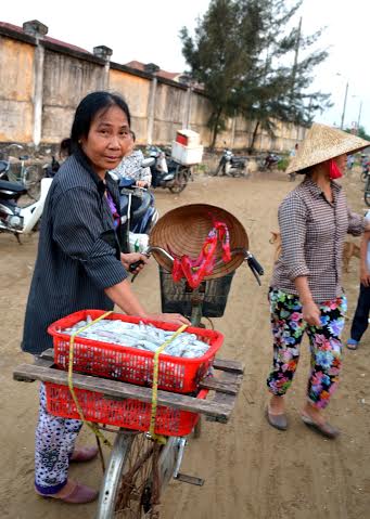 Tiểu thương đem cá đi bán khắp đường phố.