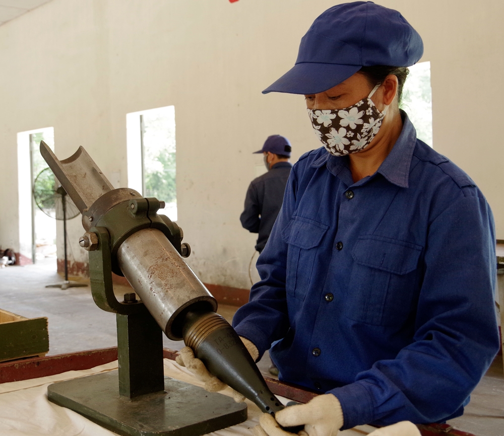 Các nhân viên của trạm sửa chữa đo đồng trục của quả đạn cối 60.