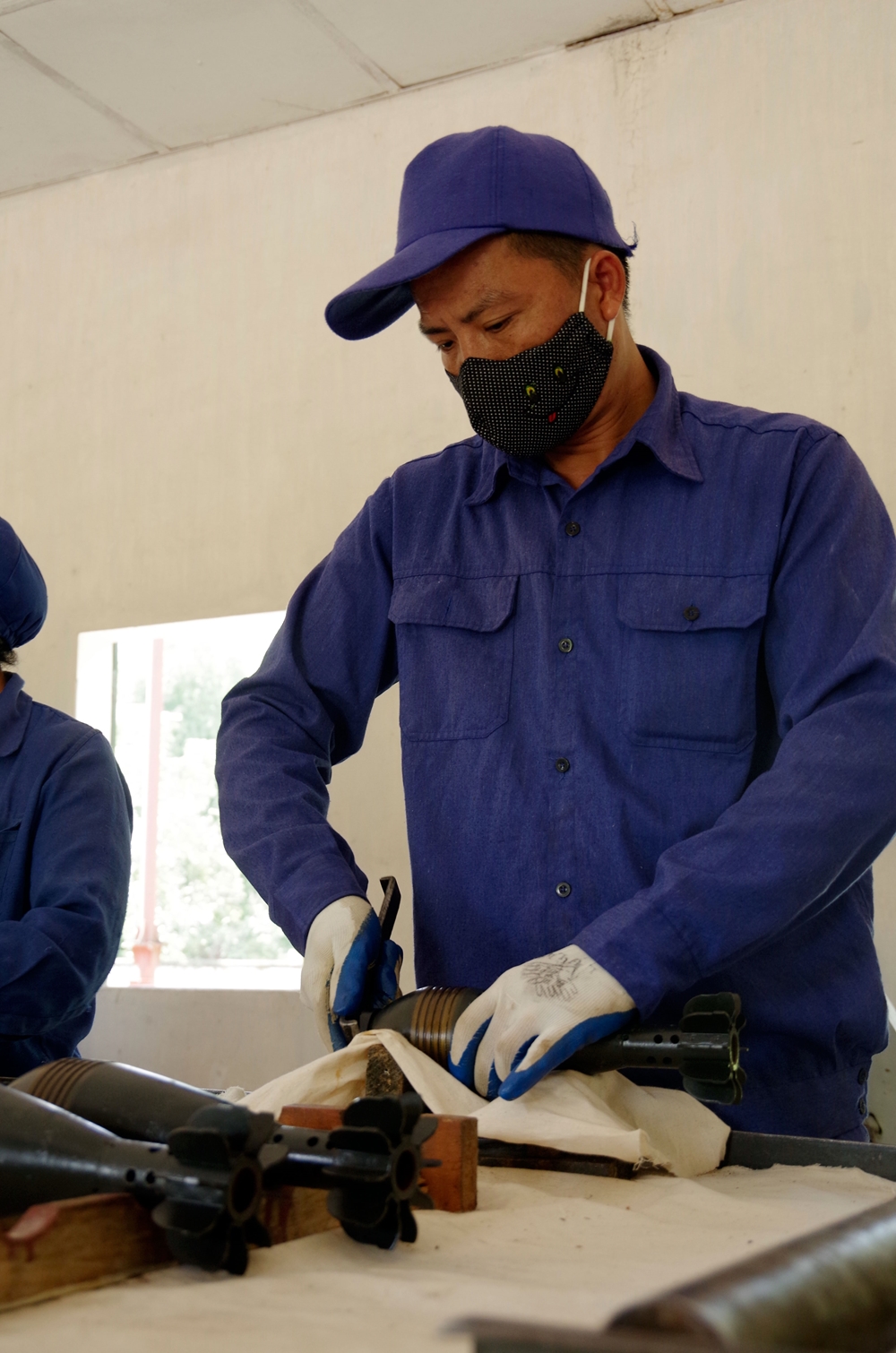 Sau khi đưa ra khỏi hòm, hộp, nhân viên sẽ tháo nút phòng ẩm ở đầu của đạn. Trong ảnh, nhân viên trạm kỹ thuật Kho 834 tháo nút phòng ẩm của đạn cối 60.