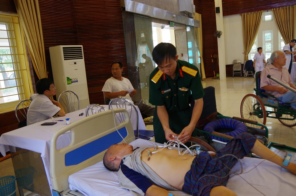 Thực hiện kỹ thuật điện tim cho thương binh nặng tại Trung tâm điều dưỡng thương binh Thuận Thành.