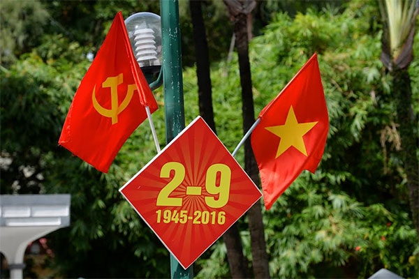 Một cách trang trí ấn tượng, màu đỏ ghi nhớ ngày Quốc khánh nổi bật trên nền của cây xanh.