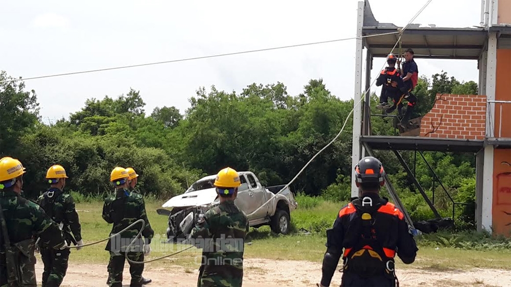 Phối hợp cùng lực lượng cứu hộ nước bạn đưa nạn nhân từ trên tầng cao xuống đất.
