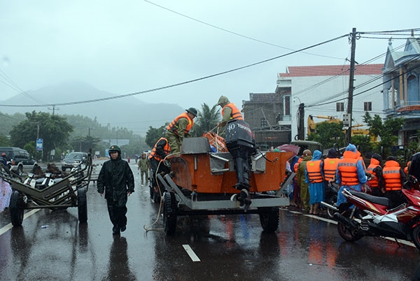 Lực lượng Bộ CHQS tỉnh Bình Định cơ động xuồng cứu hộ đến những điểm ngập lụt để di dời nhân dân.