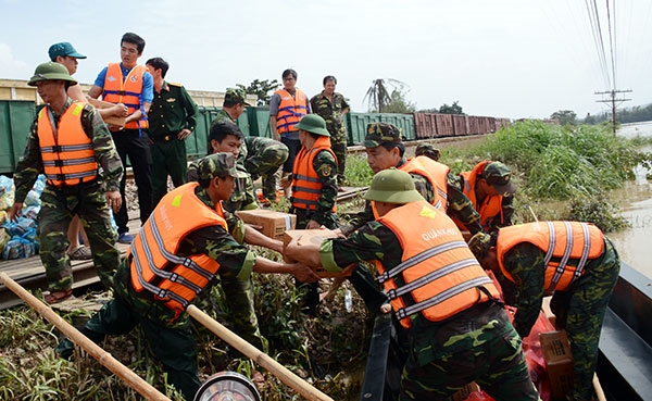 Cán bộ, chiến sĩ Bộ CHQS tỉnh Bình Định chuyển lương khô của Bộ Quốc phòng đến bà con vùng lũ.