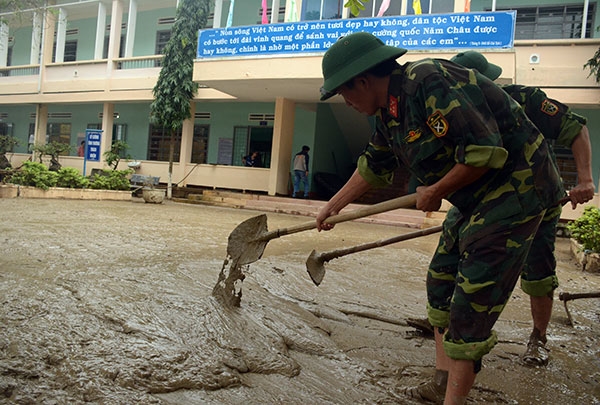 Cán bộ, chiến sĩ Lữ đoàn Phòng không 573, Quân khu 5 đã có mặt để giúp đỡ nhà trường nạo vét bùn đất.