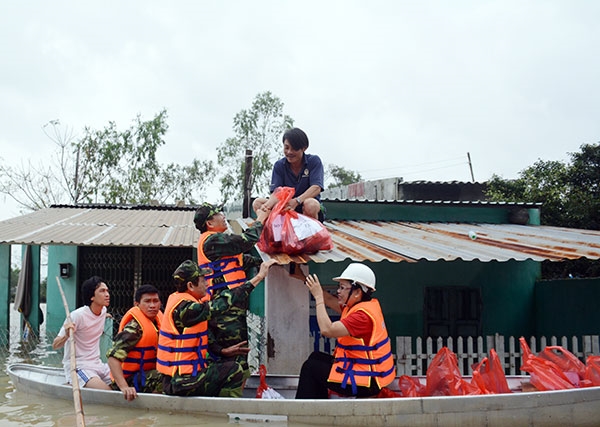 Khi nước chưa rút hẳn, nhiều gia đình phải nhận hàng cứu trợ từ trên nóc nhà.