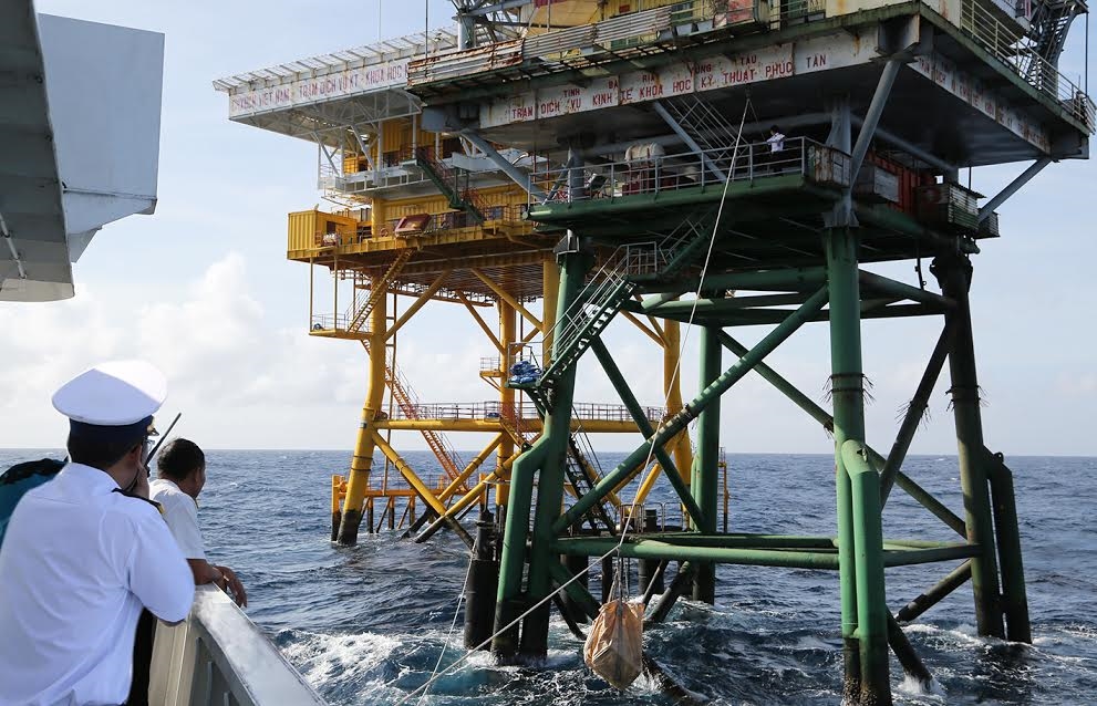 Cán bộ, chiến sĩ Tàu 264 chuyển quà lên nhà giàn bằng dòng dọc kéo hoặc cẩu hàng khi sóng lớn