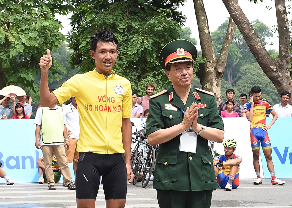 Thiếu tướng Phạm Văn Huấn, Bí thư Đảng ủy, Tổng biên tập Báo QĐND, Chủ tịch Liên đoàn Xe đạp- Mô tô thể thao Việt Nam, Trưởng Ban Tổ chức Cuộc đua, trao áo vàng chặng 1 cho VĐV Nguyễn Cường Khang.