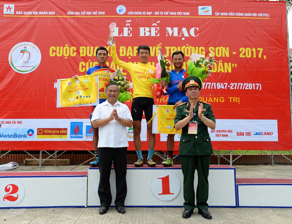 Thiếu tướng Phạm Văn Huấn và đồng chí Phạm Văn Tuấn, Phó tổng cục trưởng Tổng cục Thể dục, Thể thao, trao áo vàng chung cuộc, tặng hoa tay đua Nguyễn Cường Khang và chụp ảnh lưu niệm cùng 3 tay đua giành giải nhất, nhì, ba chung cuộc: Nguyễn Cường Khang, Nguyễn Tấn Hoài, Lê Nguyệt Minh.