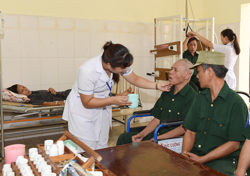 Các y tá động viên và cho bệnh nhân uống thuốc.