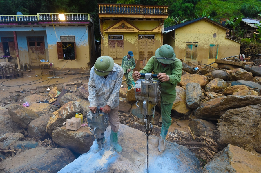 Cán bộ, chiến sĩ Đại đội Công binh thuộc Bộ Chỉ huy Quân sự tỉnh Yên Bái phá đá, tìm kiếm các nạn nhân bị mất tích trong cơn lũ.