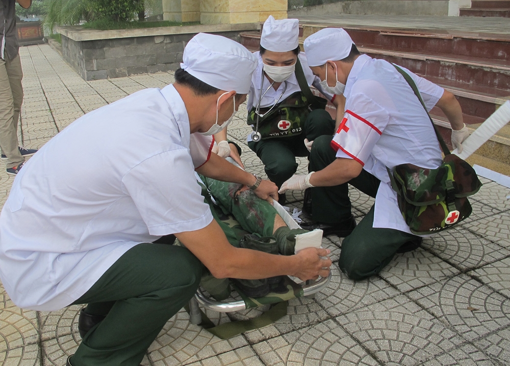 Lực lượng quân y nhanh chóng sơ cứu người bị nạn.