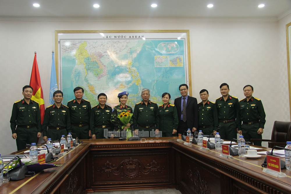 Thiếu tá Đỗ Thị Hằng Nga chụp ảnh cùng Thủ trưởng Bộ Quốc phòng, đại diện Bộ Ngoại giao, đại diện Cục Đối ngoại, Cục Cán bộ, Cục Tuyên huấn và lãnh đạo Trung tâm GGHB Việt Nam.