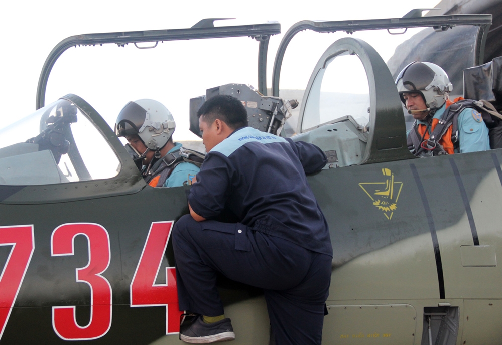 Nhân viên kỹ thuật hỗ trợ phi công mở máy huấn luyện.