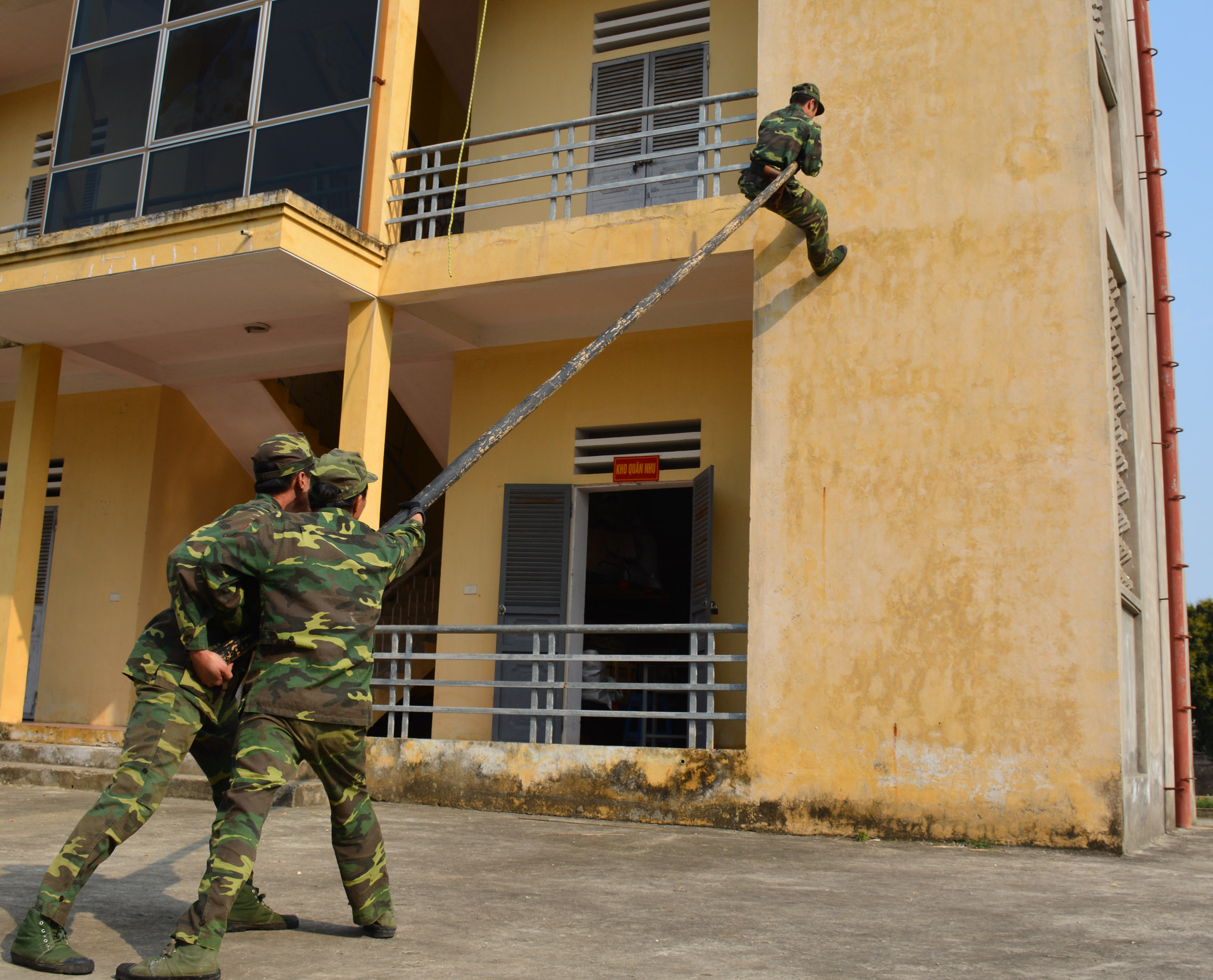 Dùng sào đẩy leo lên nhà cao tầng.