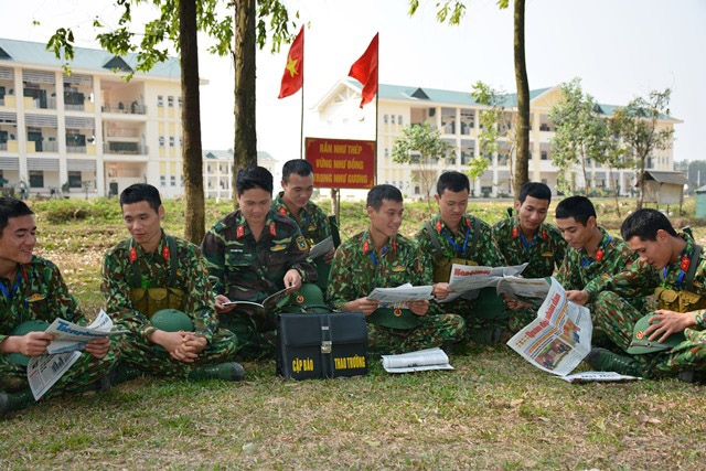 Cán bộ, chiến sĩ cùng nhau đọc báo trong giờ nghỉ giải lao.