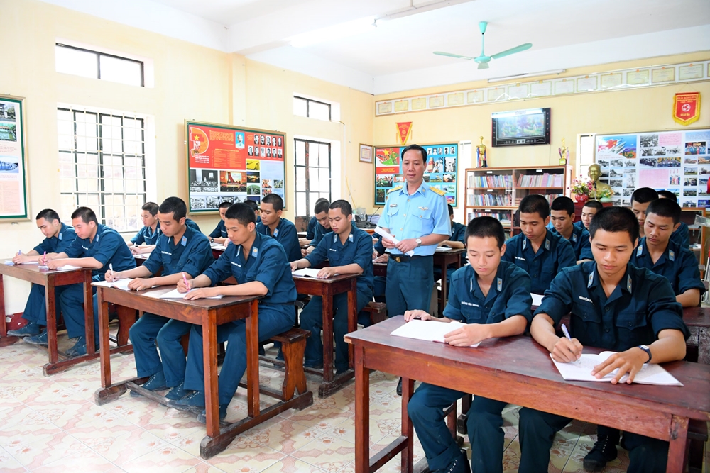 Toàn bộ chiến sĩ mới năm nay của Lữ đoàn thông tin 26 được đưa về huấn luyện tại Tiểu đoàn 20. Trong ảnh: Trung tá Hoàng Minh Thao, Chính trị viên Tiểu đoàn 20, kiểm tra chất lượng ghi chép bài học chính trị của chiến sĩ mới.