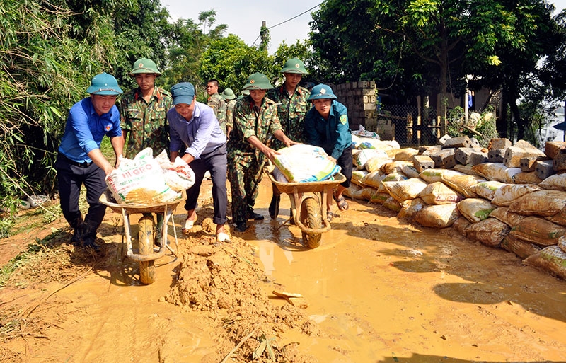 Bộ đội và dân quân đắp bờ bao ngăn nước ở đê Đồng Ao, xã Đông Yên, huyện Quốc Oai, Hà Nội.