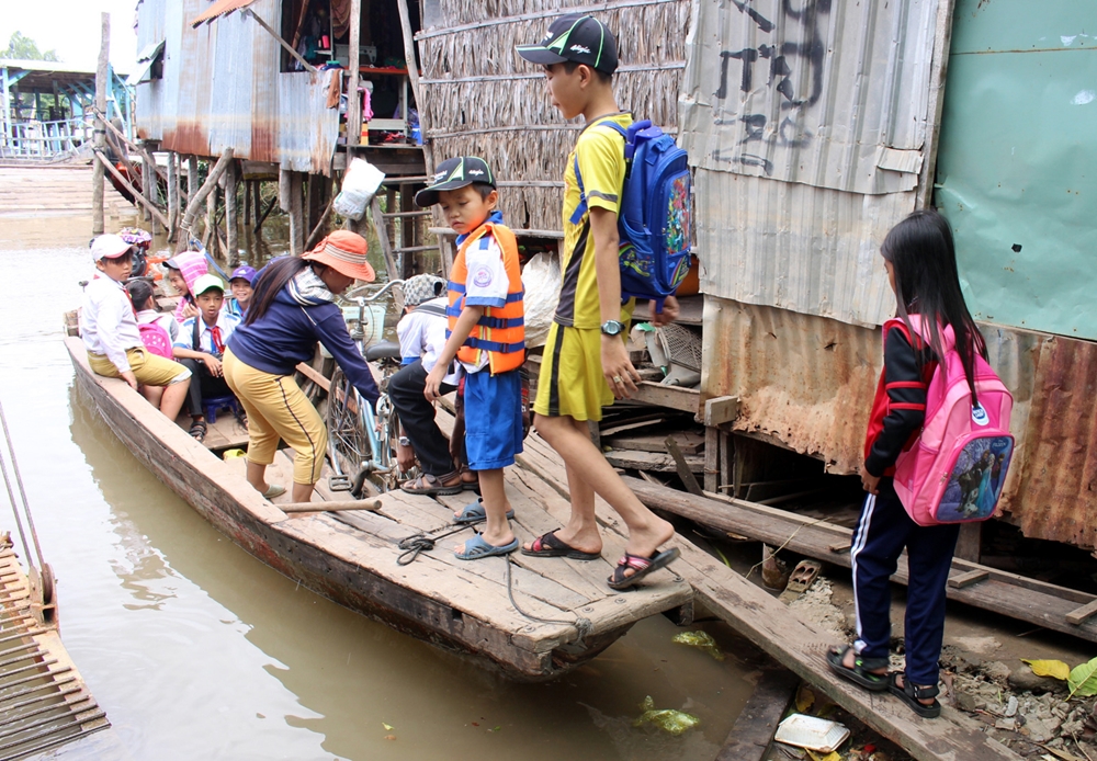 Học sinh vượt lũ đi khai giảng tại huyện đầu nguồn biên giới An Phú (An Giang), nơi tiếp giáp với Campuchia.