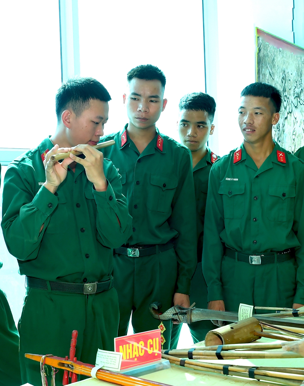 Binh nhất Đặng Văn Trọng, dân tộc Dao, Đại đội 17 đang giới thiệu với đồng đội cây sáo của đồng bào Dao.
