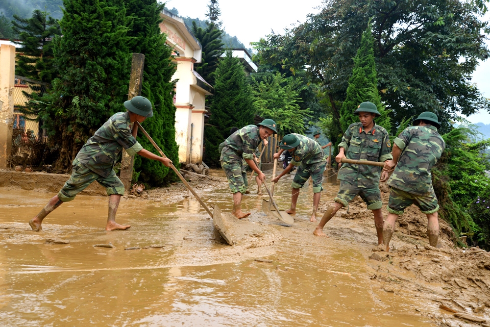 Cán bộ, chiến sĩ Trung đoàn 174, Sư đoàn 316 giúp người dân Bản Phình Hồ, xã Dế Xu Phình, huyện Mù Cang Chải (Yên Bái) giúp chính quyền và nhân dân huyện Mù Cang Chải dọn dẹp, vệ sinh môi trường sau lũ quét tháng 8-2017.