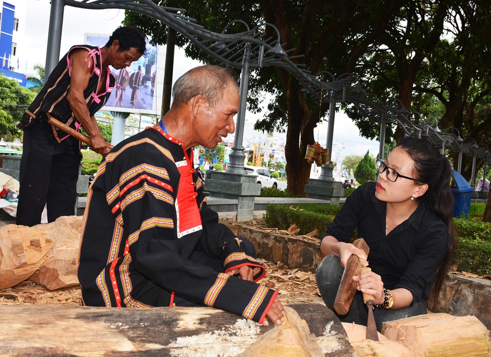 Du khách giao lưu với nghệ nhân tạc tượng.