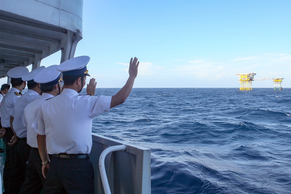 Cán bộ Vùng 2 Hải quân tham gia đoàn công tác vẫy chào đồng đội trước khi tàu rời đi.