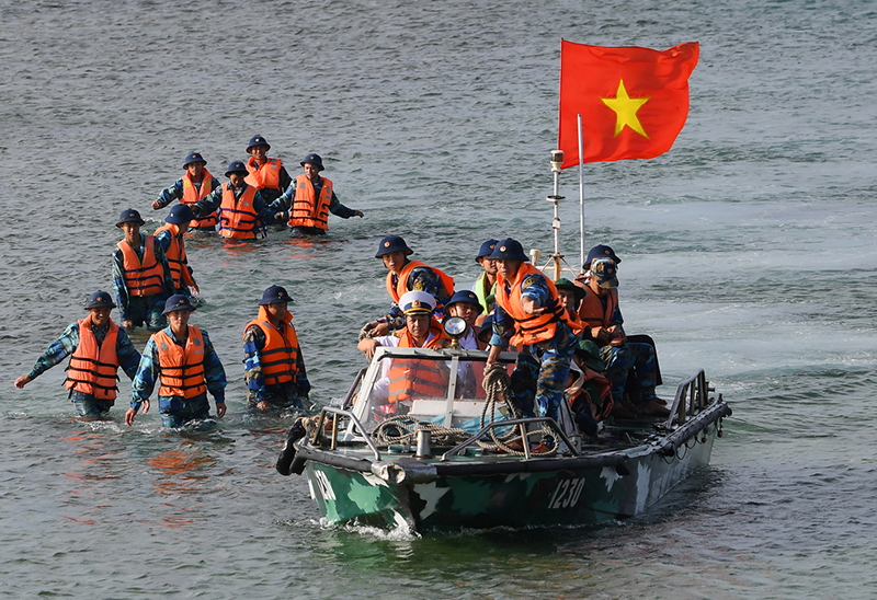 Cán bộ, chiến sĩ dầm mình giữa trùng khơi phân luồng dẫn đoàn công tác vào đảo.