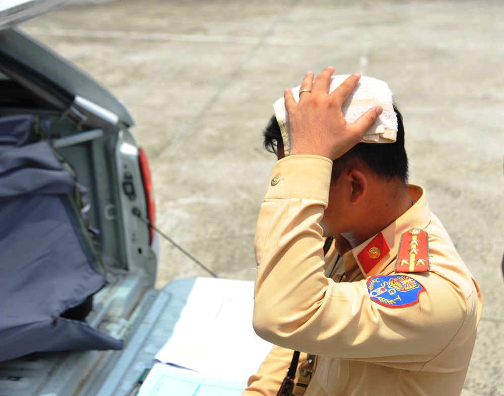 Dùng khăn ướt để giảm cái nóng như “đổ lửa” ngoài trời.