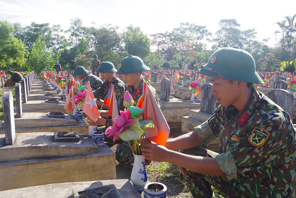 Cán bộ, chiến sĩ Sư đoàn 324 chăm sóc các ngôi mộ ở Nghĩa trang Liệt sĩ Việt - Lào