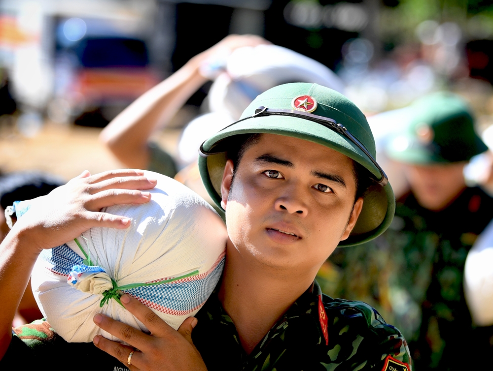 Gần 1 ngày hành quân, thức trắng 1 đêm cùng với bộ đội bắc cầu, Đại úy Nguyễn Viết Hiếu (Lữ đoàn Công binh 414 - Quân khu 4) tiếp tục tham gia vận chuyển hàng cứu trợ đến từng hộ dân bản Sa Ná.