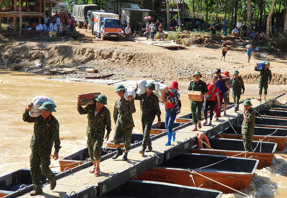 Bộ đội cùng người dân tham gia vận chuyển hàng cứu trợ, cùng nhu yếu phẩm thiết yếu đến từng gia đình bị thiệt hại do cơn lũ trong bản Sa Ná.