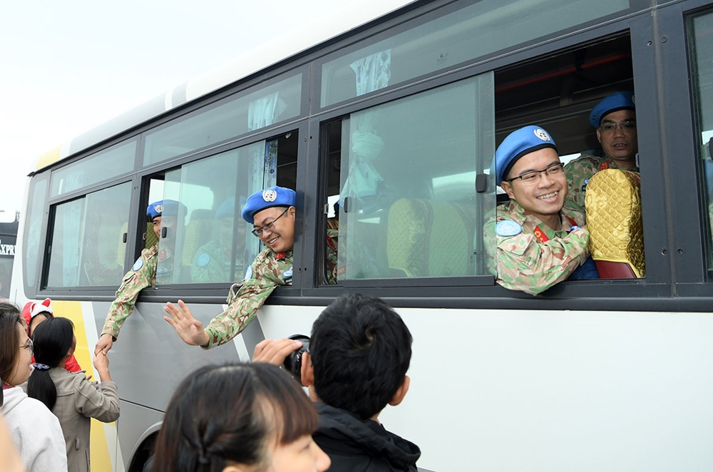 Chia tay người thân, các cán bộ, nhân viên lên ô tô cơ động ra máy bay.