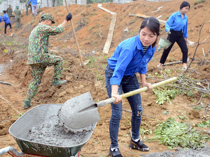 Các nữ đoàn viên phục vụ việc xây dựng tường rào.