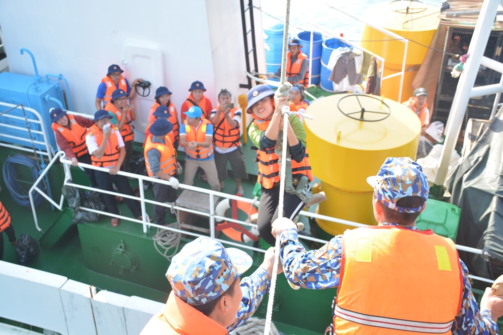 Hàng và quà Tết đều được chuyển cho các nhà giàn an toàn cho dù sóng to, gió lớn. Thế nhưng, đưa được đoàn công tác lên nhà giàn hay không còn phụ thuộc vào điều kiện cụ thể của từng nhà giàn và thời tiết. Trong ảnh: Một nữ nhà báo đang được kéo lên nhà giàn.