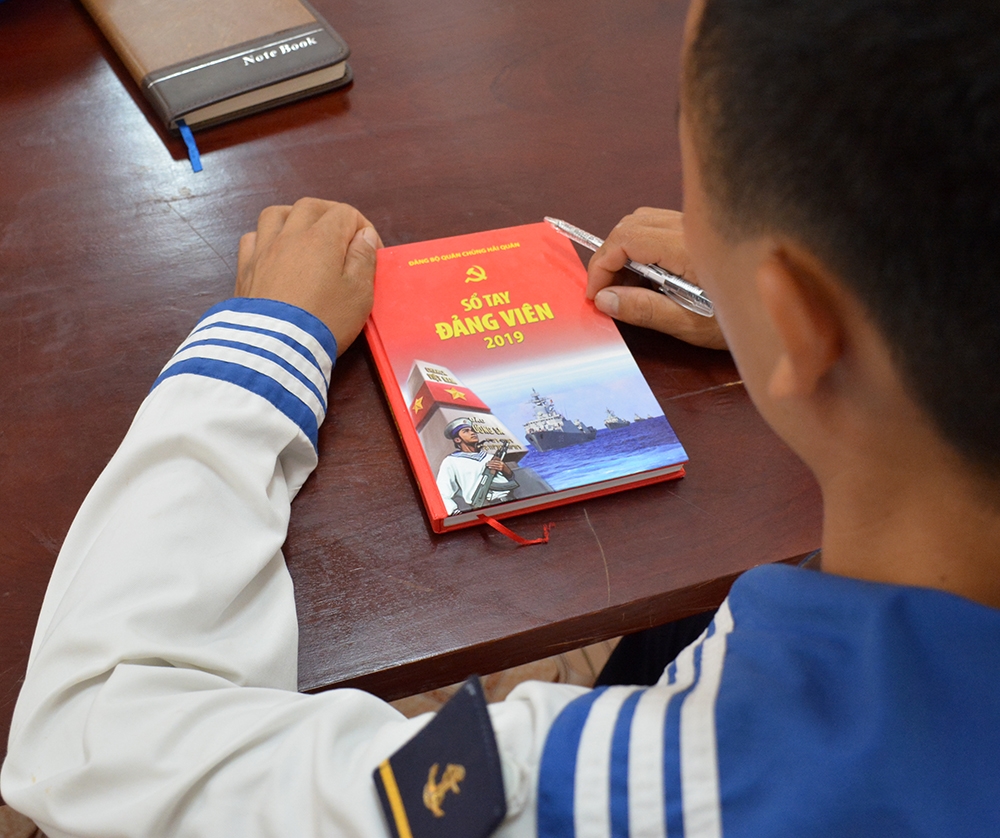 Đảng viên mới Đỗ Trịnh Tuế với cuốn sổ tay đảng viên đầu tiên.