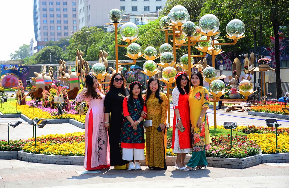Những du khách đầu tiên tham quan, chụp ảnh tại đường hoa Nguyễn Huệ.