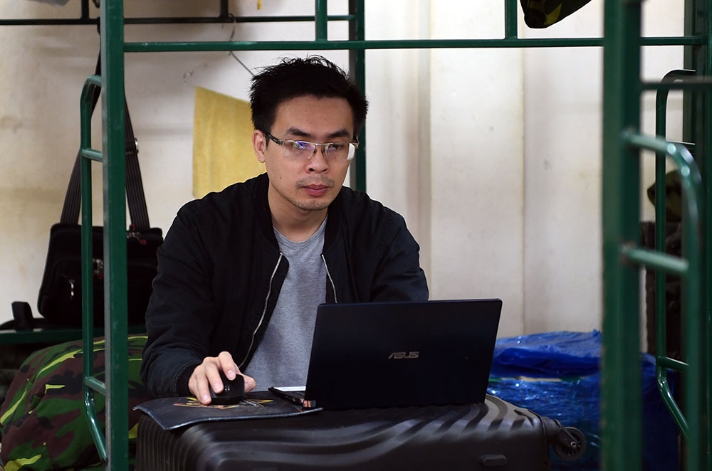 Một lao động Việt Nam trở về từ Hàn Quốc vẫn miệt mài làm việc bên máy tính dù đang trong thời gian cách ly.
