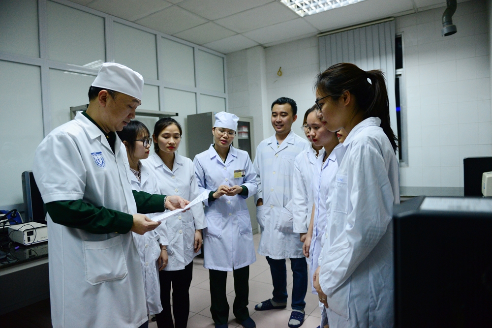 Thượng tá Hồ Anh Sơn (bên trái), Phó giám đốc Viện nghiên cứu Y dược, Học viện Quân y trao đổi kinh nghiệm với nhóm nghiên cứu.