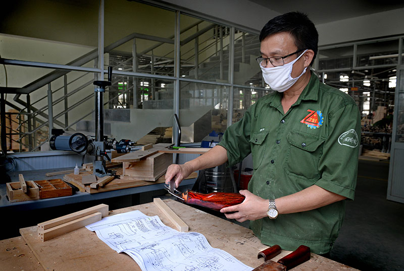 Thiếu tá QNCN Lương Vũ Sinh, nhân viên kỹ thuật Xí nghiệp mộc kiểm tra thông số chế tạo báng súng, óp lót tay tiểu liên AK.