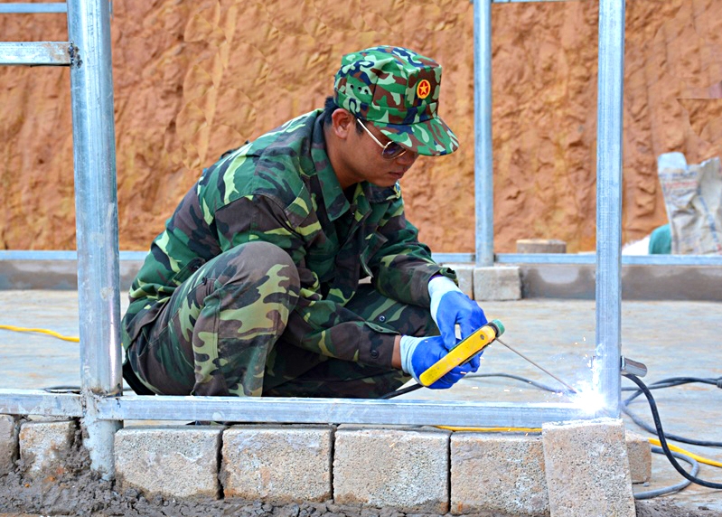 Một quân nhân Đoàn KT-QP 379 đang hàn dựng khung thép tại bản Long Dạo, xã Si Pa Phìn.