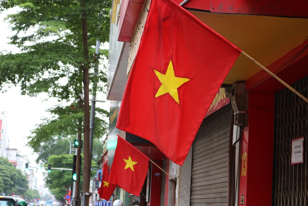 Cờ đỏ sao vàng được treo trước cửa nhiều hộ dân và cơ quan nhà nước.