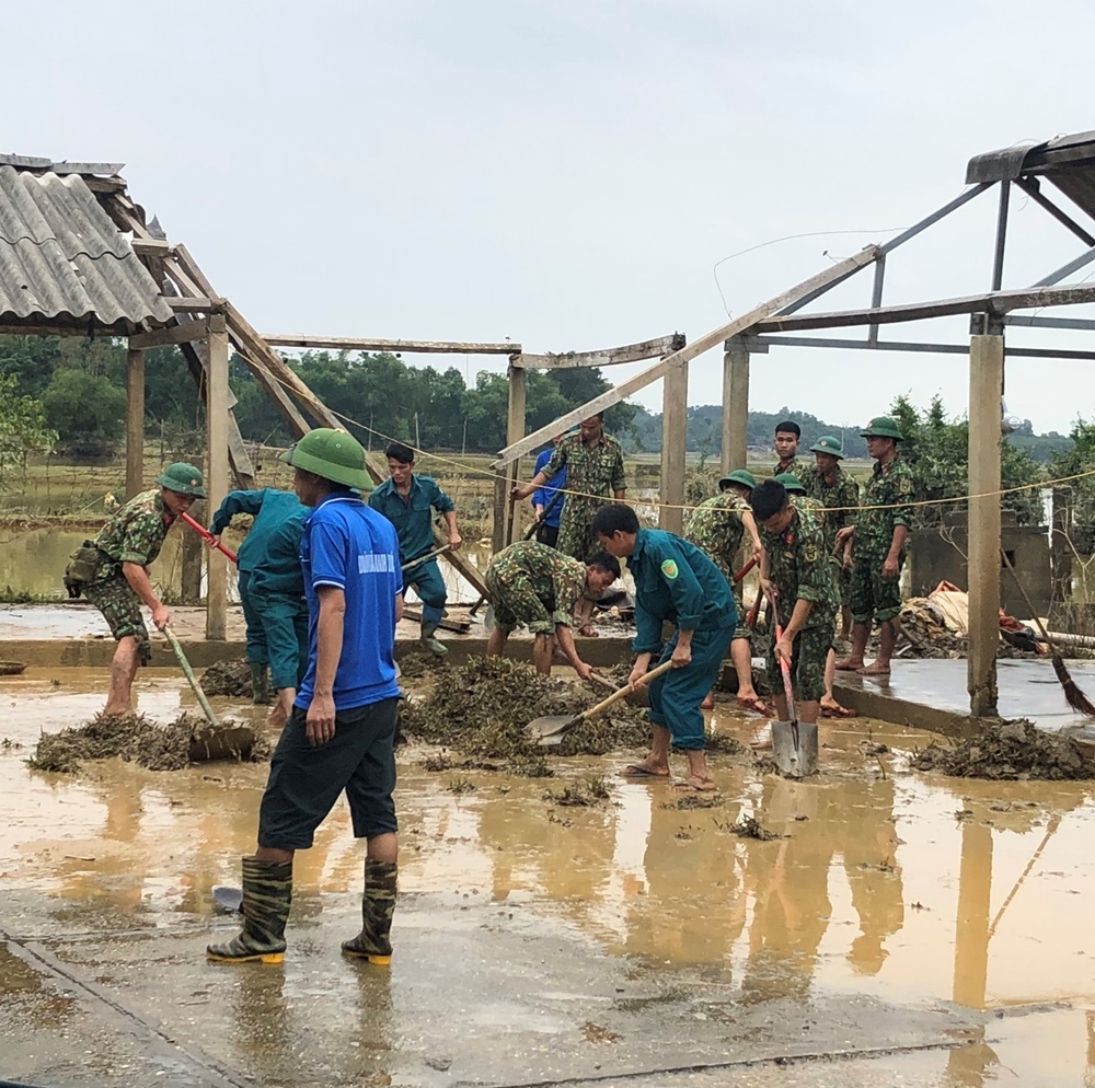 Bộ đội phối hợp với các cấp chính quyền địa phương thu dọn đống đổ nát ở chợ Đàng xã Thanh Xuân, huyện Thanh Chương.