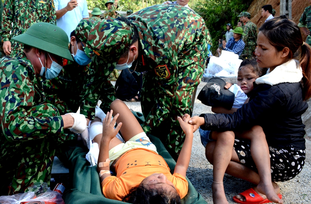Lực lượng Quân y Quân khu 5 sơ cứu cháu bé bị gãy chân trong trận lũ.