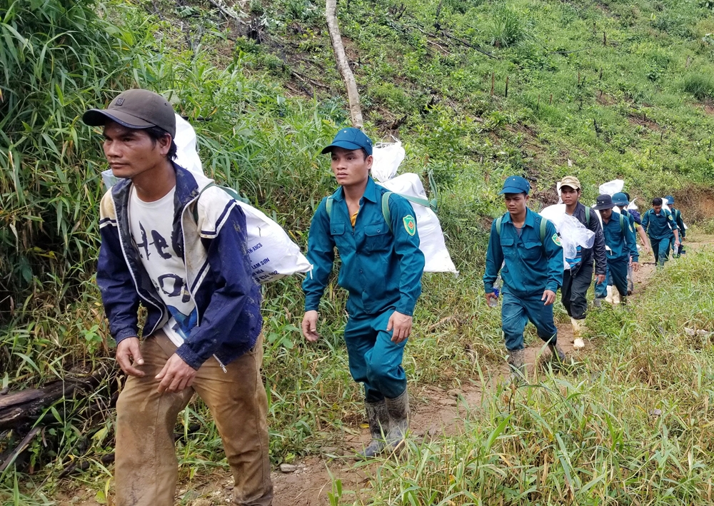 Lực lượng dân quân cũng tích cực tham gia cõng gạo cứu trợ đồng bào Phước Lộc.