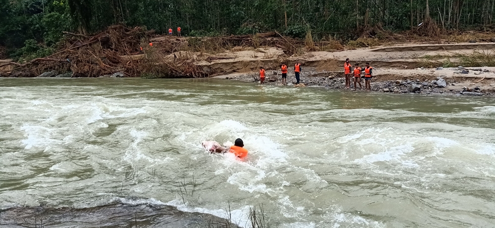 Bộ đội, Công an, Dân quân tự vệ vật lộn với dòng nước dữ, bơi qua sông Leng, dùng bè chuối, dây cáp đưa thi thể nạn nhân vụ sạt lở đất bị mắc lại trong một hốc cây, cách mặt nước hàng chục mét về để mai táng.